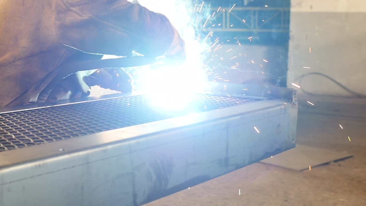 보호복을 입고 금속 가공 환경에서 일하는 용접기