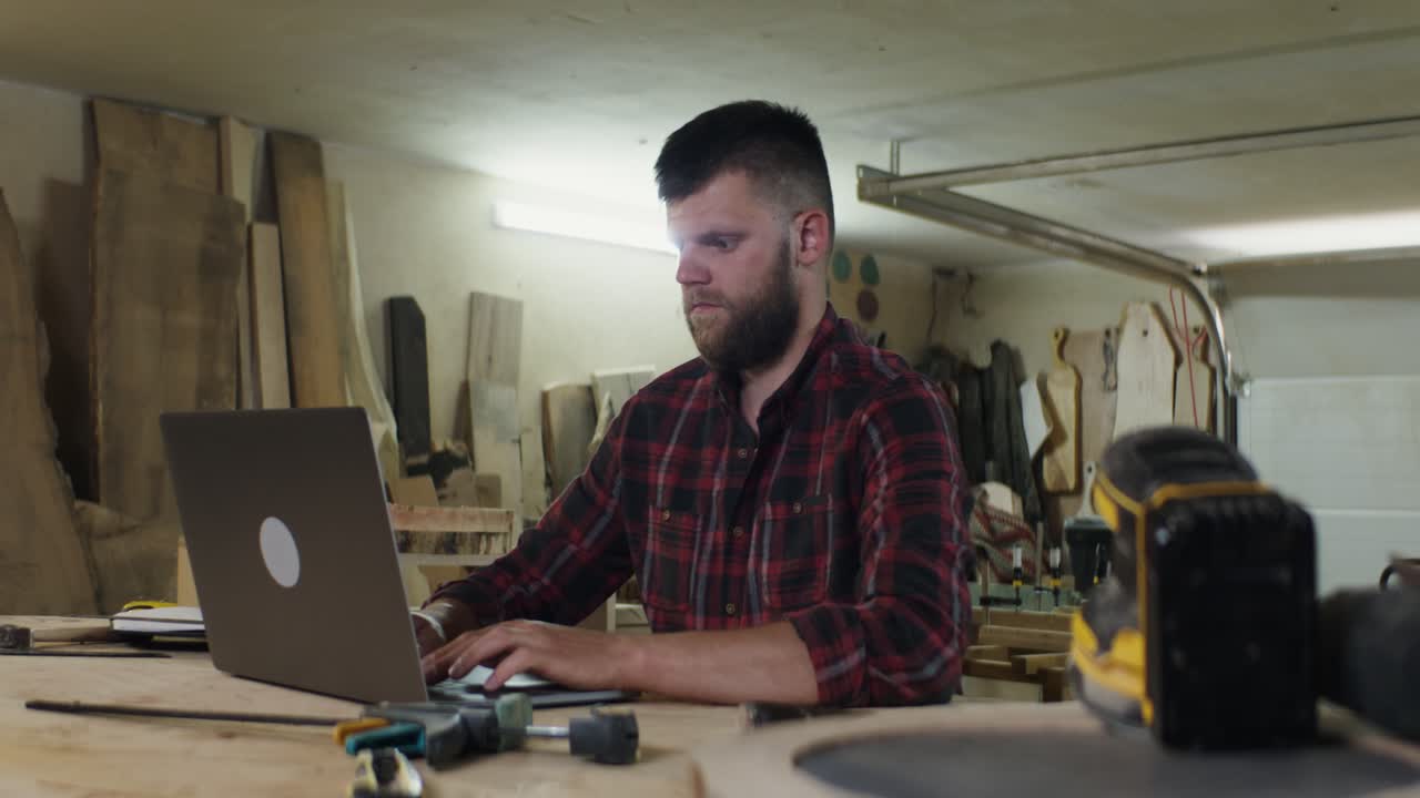 Woodworker using Laptop in Workshop
