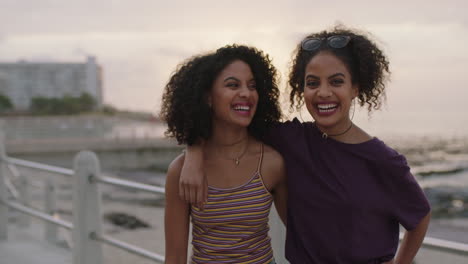 two loving hispanic sisters embrace laughing cheerful posing happy looking at camera