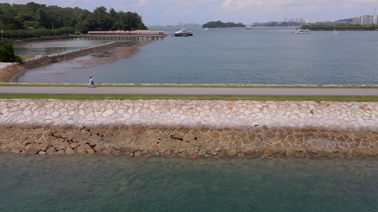 싱가포르 세인트 존 섬 근처의 고요한 바다 한가운데 사람들이 건너는 경치 좋은 다리