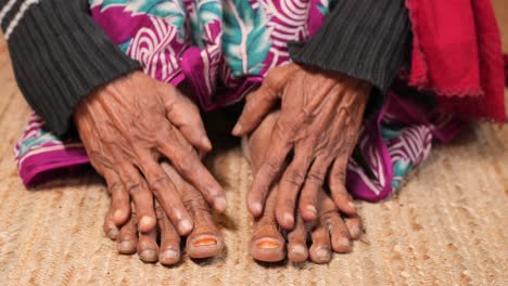 primer plano de las manos y los pies de una anciana