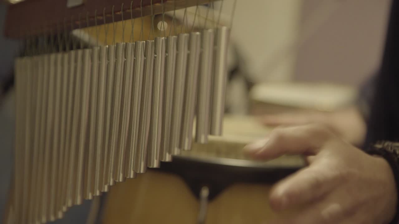 Close up view of drummer giving special effects with bar chimes during live performance.