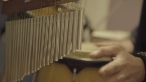 close up view of drummer giving special effects with bar chimes during live performance.