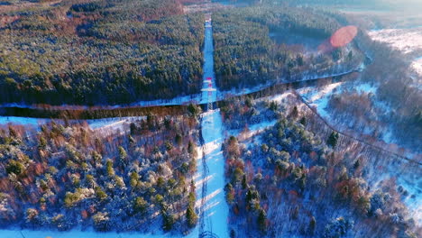 electric towers in winter forest. high voltage power lines. aerial forest