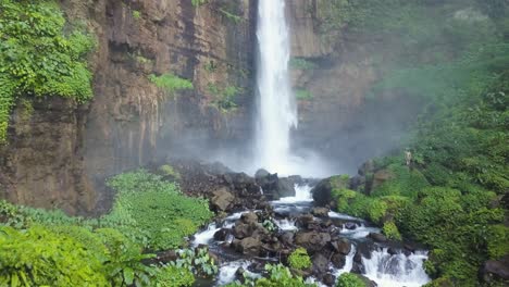vista increíble del hombre parado frente a la cascada