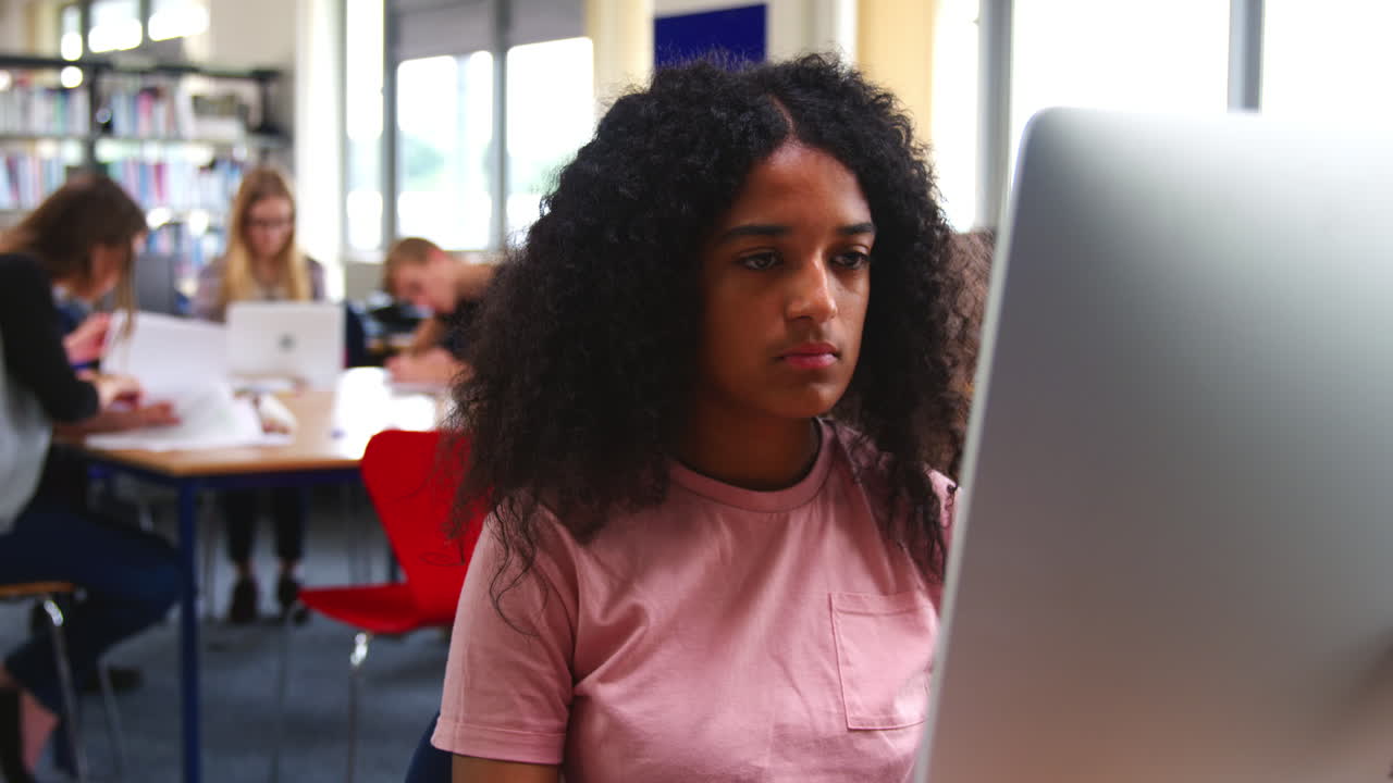 Female Student Working On Computer In College Library