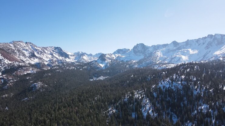 Drone che vola verso montagne innevate a Mammoth Lakes, California
