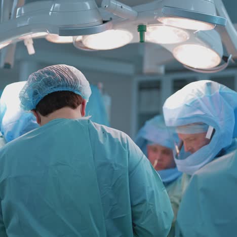 operating theater. team of doctors doing a surgery to a patient lying on operating table. group of surgeons in medical uniform in operating room