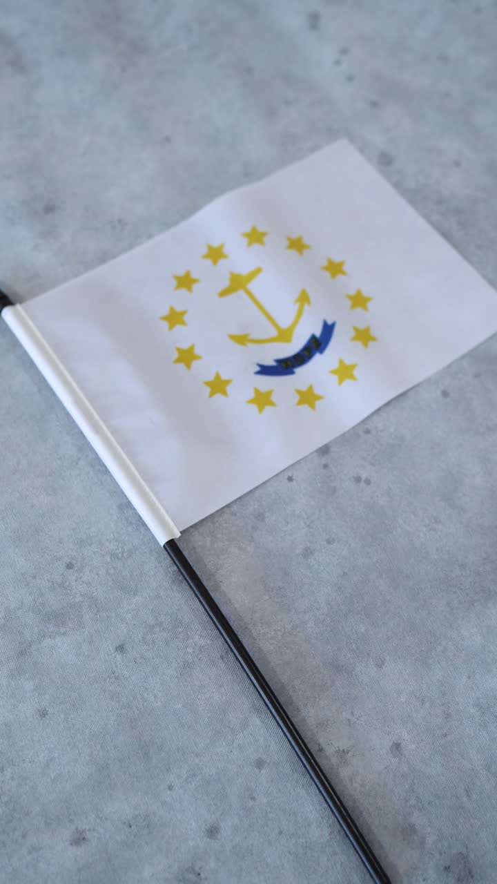 Státní vlajka Rhode Islandu na šedém pozadí. Vertikální záběr