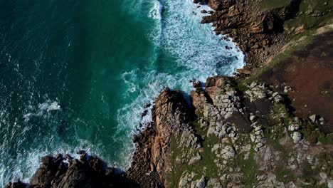 cornish coastline along cliffs and bays with scenic landscape views, aerial tilt up shot