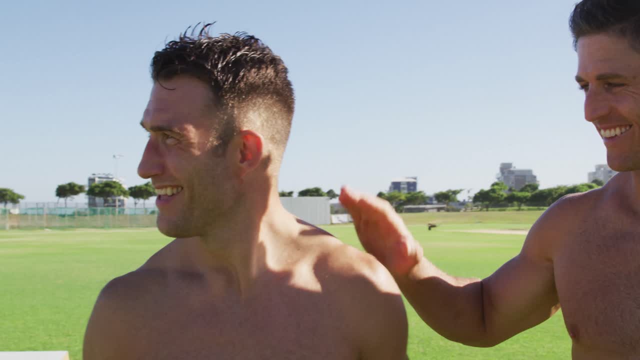 셔츠 없는 세 명 의 다양한 몸매 를 가진 남자 들 이 야외 에서 운동 을 한 후 미소 짓고 주먹 을  ⁇ 고 있다