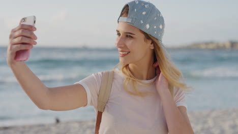 Retrato-De-Una-Linda-Mujer-Rubia-Tomando-Una-Foto-Selfie-En-La-Playa-Usando-La-Tecnología-De-La-Cámara-De-Un-Teléfono-Inteligente-Disfrutando-Compartiendo-Experiencias-De-Vacaciones-Comunicación-Móvil-En-Línea