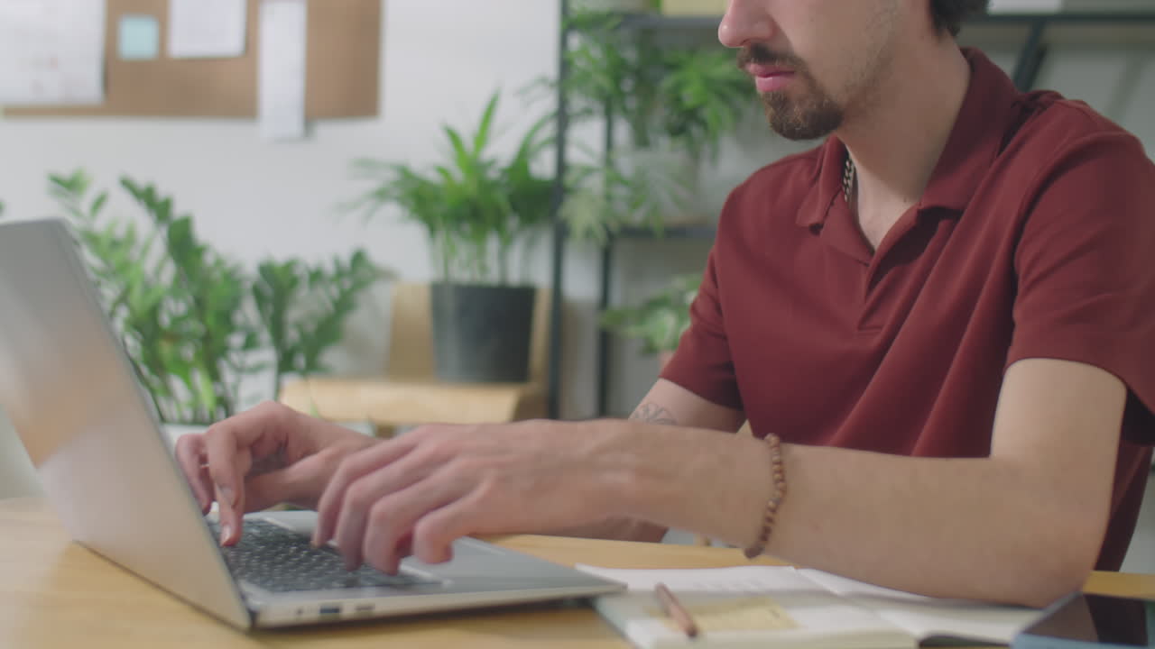Male Office Clerk Working on Laptop at Desk
