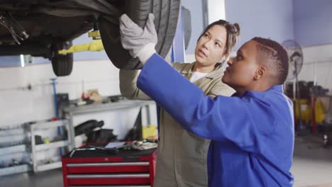 Video-of-two-diverse-female-car-mechanics-wheel