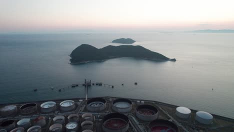 Drone-Aéreo-Vuela-Sobre-Tanques-De-Gasolina-Refinería-Isla-Japonesa-Puesta-De-Sol-Paisaje-Playa-Mar-En-El-Horizonte-De-Wakayama-En-El-Puerto-Destino-De-Viaje,-Japón-Asia-Océano-Pacífico