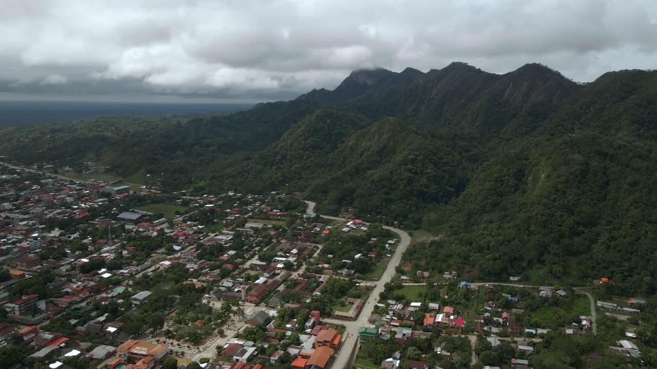 High altitude drone establishing the town of Rurrenabaque, Bolivia, surrounded by lush jungle and rivers with tall mountains