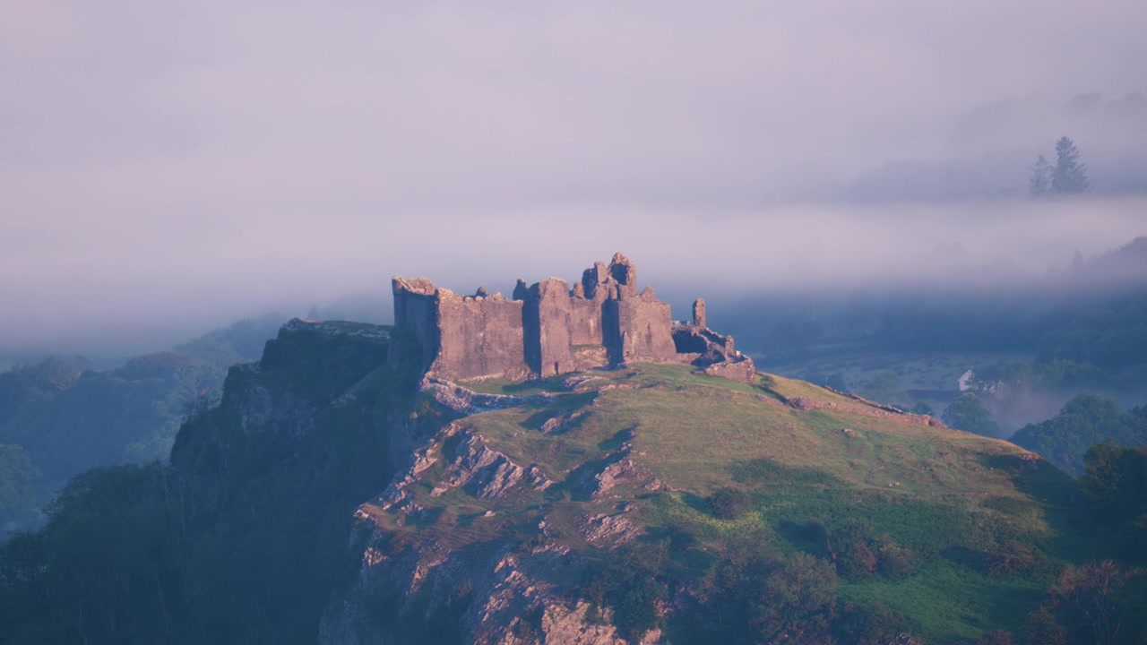 Vista del Castello di Carreg Cennen su un'alta cima di montagna nel Galles del Sud all'alba. Storia gallese con nebbia atmosferica. Architettura medievale.