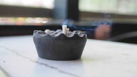 ashtray with cigarette and smoke