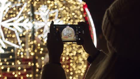 Frau-Fotografiert-Weihnachtsbeleuchtung---Nahaufnahme-Eines-Mobiltelefons