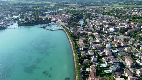 High-angle-aerial-over-shoreline-of-Peschiera-del-Garda-lake,-Verona,-Italy