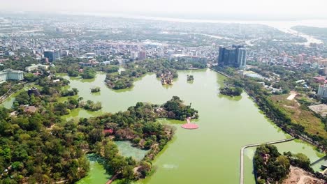 a stunning aerial perspective of kandawgyi lake in rangun, myanmar, showcasing its lush green surroundings, small islands, and the vibrant cityscape in the background