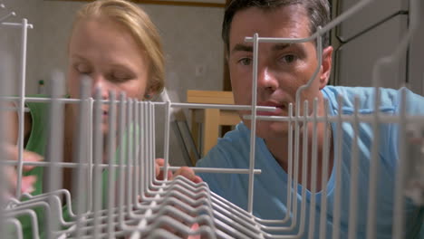 Family-couple-putting-plates-into-the-dishwasher