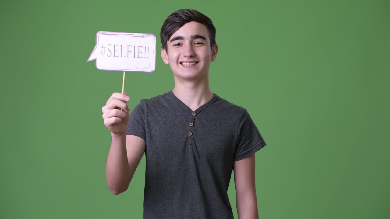 joven y guapo adolescente iraní contra un fondo verde