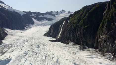 Vista-Aérea-Del-Glaciar-Y-La-Cascada-Glacial-Que-Cae-Sobre-El-Hielo-En-Un-Día-Soleado,-Alaska,-Ee.uu.,-Levanta-El-Tiro-Del-Dron