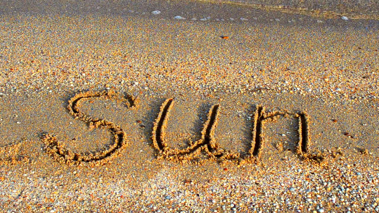 Solindskrift i sandet, stranden. Solskinsdag, afslapning