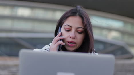 mujer joven con cabello teñido hablando en el teléfono inteligente al aire libre