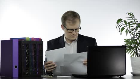 hombre de negocios trabajando en la oficina. haciendo análisis de informes leyendo papeles en la mesa