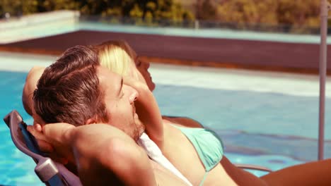 Couple-relaxing-on-deck-chairs