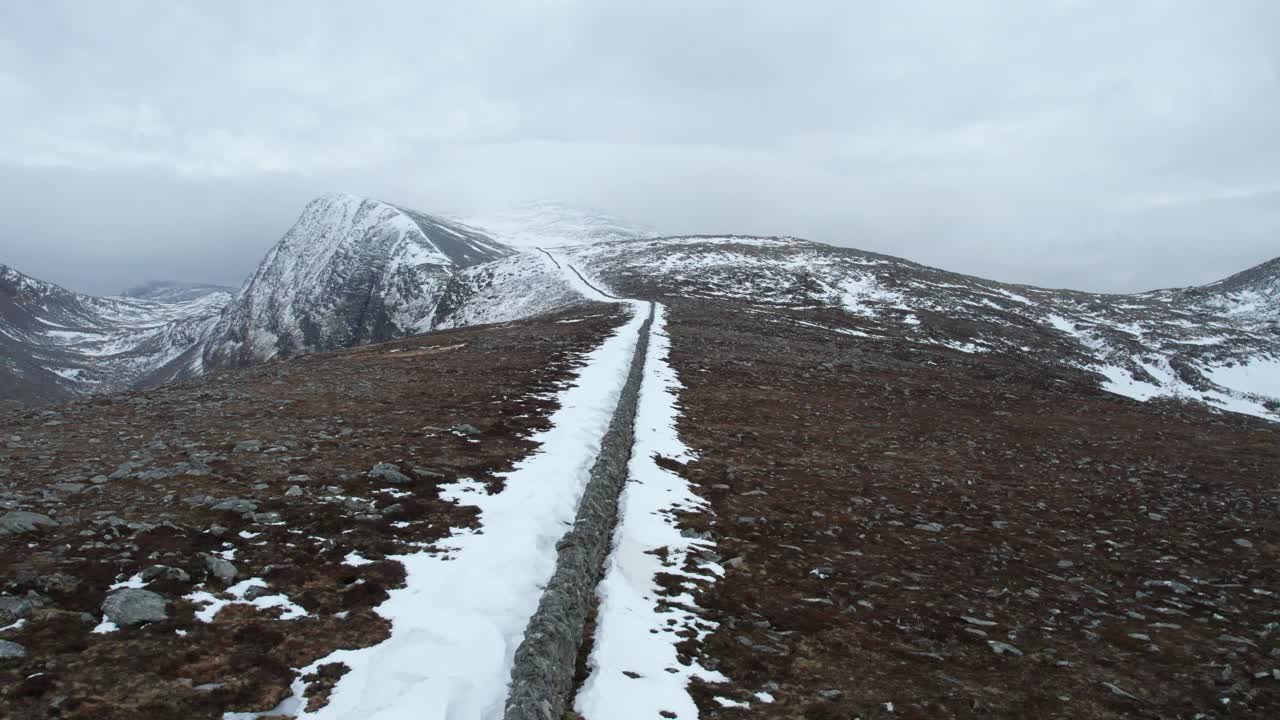 Aerial view of a historic starvation wall in the mountains of the Scottish Highlands during winter