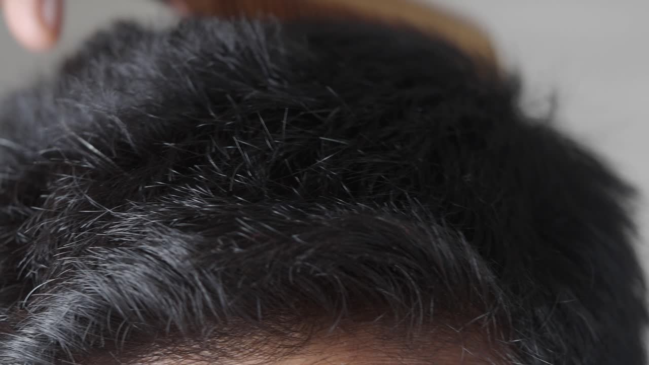 Closeup of a man combing his hair