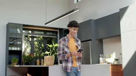 using smartphone, child standing in modern kitchen, smiling