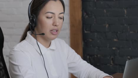 woman call centre operator, customer support agent wears headset consults client online, typing on laptop, talk in internet computer chat, helpline operator secretary make conference video call