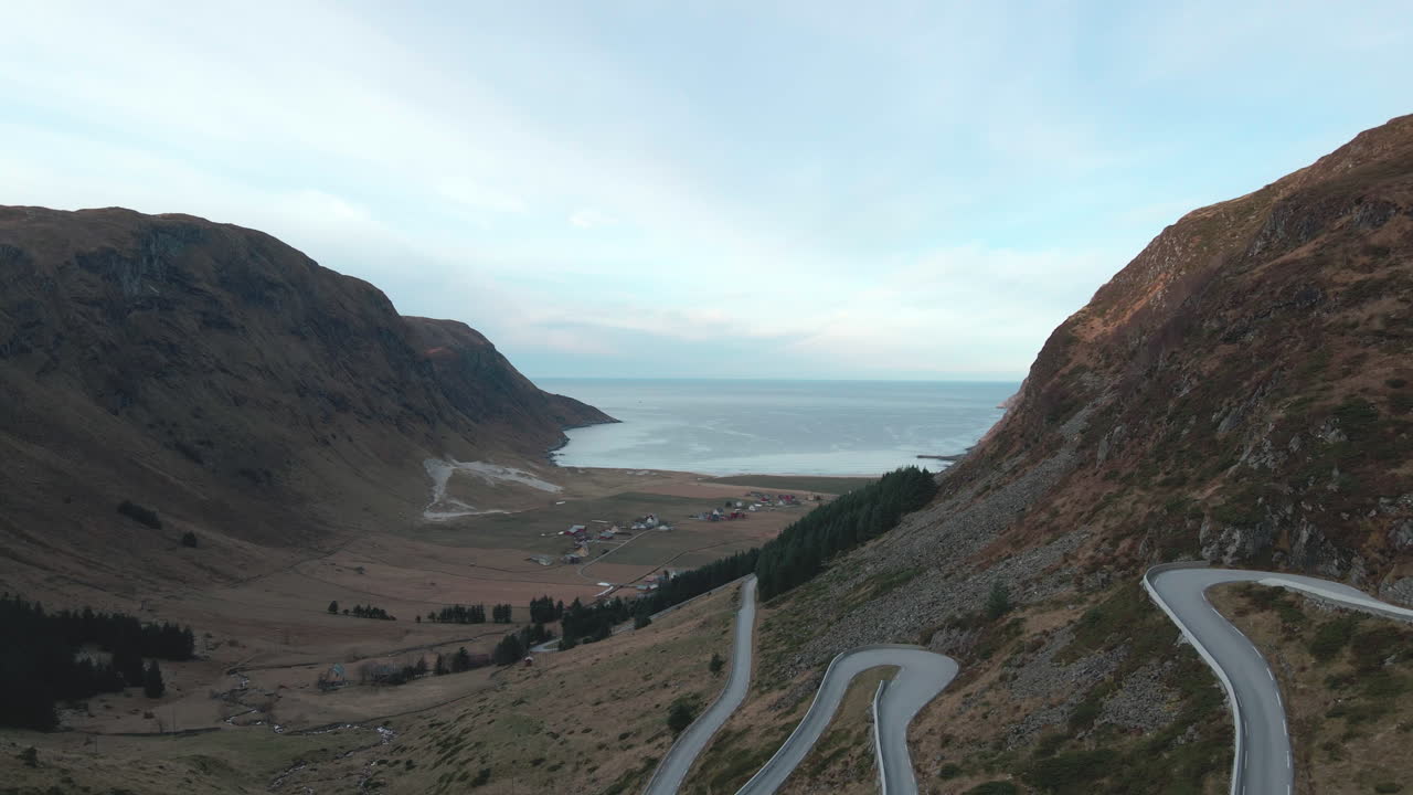 Drone shot flying into the valley over the road and are looking out into the horizon