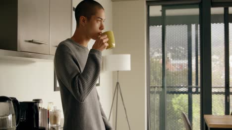 man having coffee in kitchen at home 4k