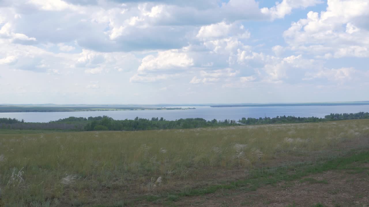 vista panorámica de un lago y un campo cubierto de hierba