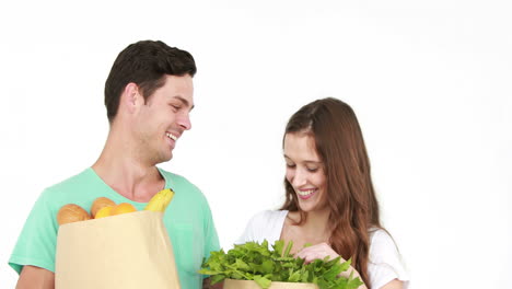una pareja joven con bolsas de comestibles