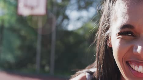 Half-portrait-of-happy-african-american-female-basketball-player-in-sun,-copy-space,-slow-motion