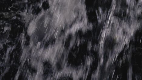 disparo en cámara lenta de agua de una cascada cayendo en la palma de la mano de una mujer