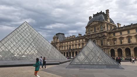 louvre museum in paris under cloudy sky