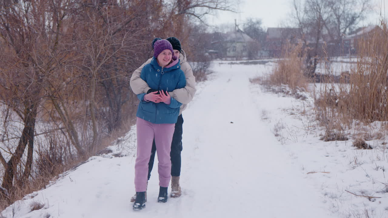눈 인 길 에서 포옹 하는 부부