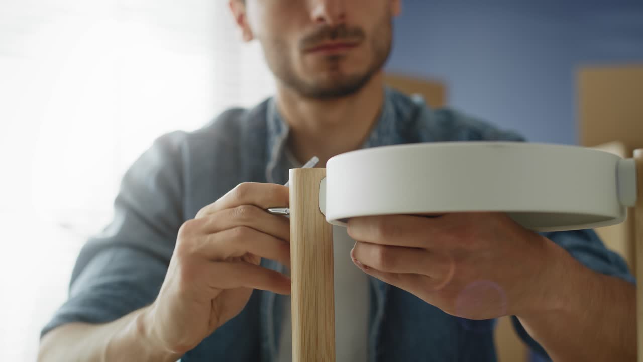 가구를 설치하는 젊은 남자의 비디오.