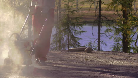 construction worker compacting soil using vibratory plate compactor