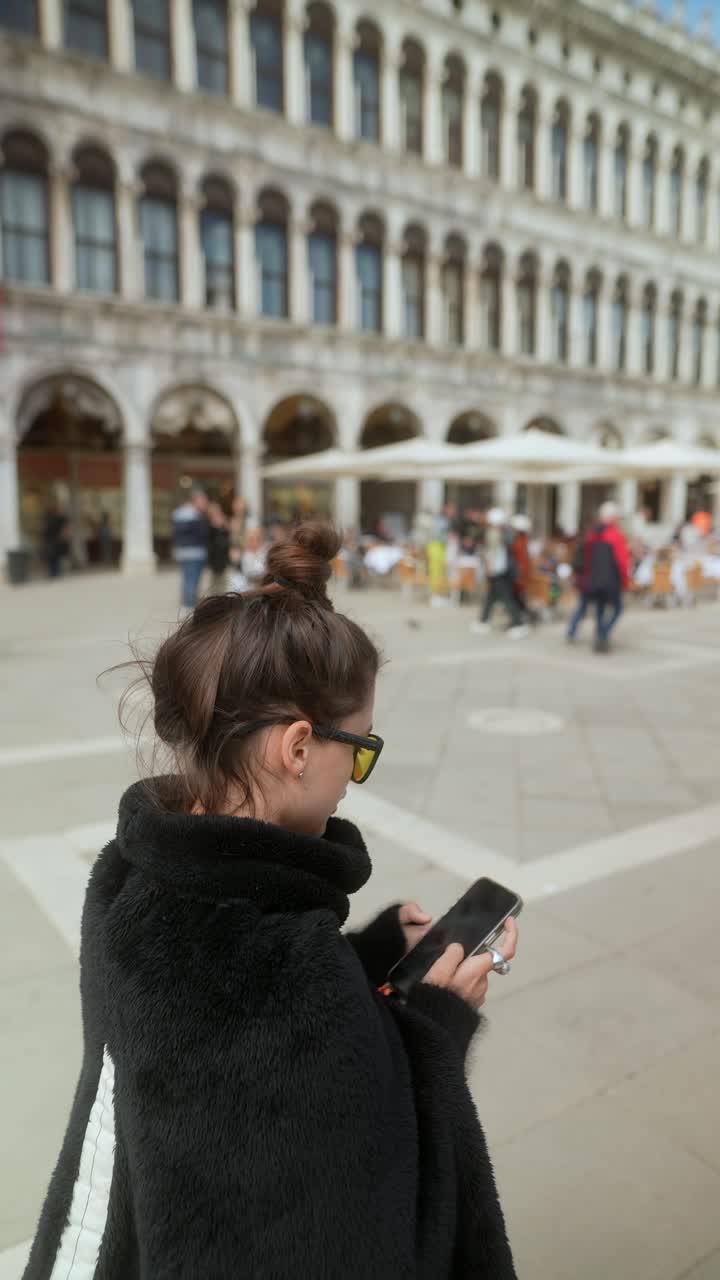 베네치아 성 마르코 광장에서 전화를 사용하는 여성