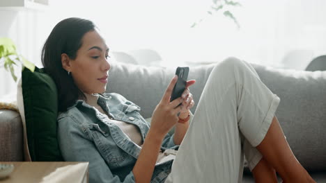 Woman,-relax-and-typing-on-smartphone-on-sofa