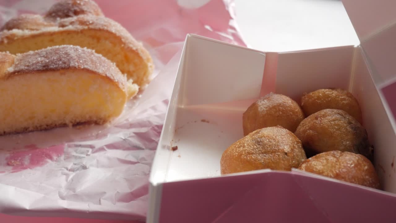 Close up of a hand reaching for some delicious pastries and sweet treats