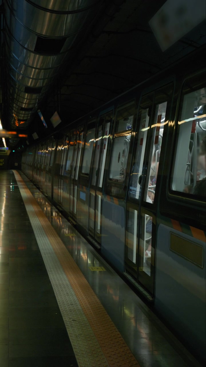 Il treno della metropolitana di Napoli parte dalla stazione, che è affollata di turisti.
